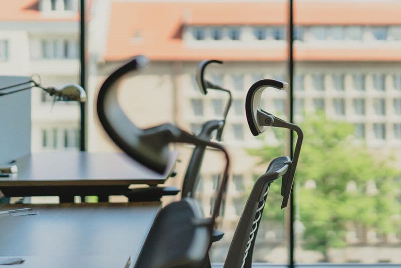 Office chairs and desks beside large windows