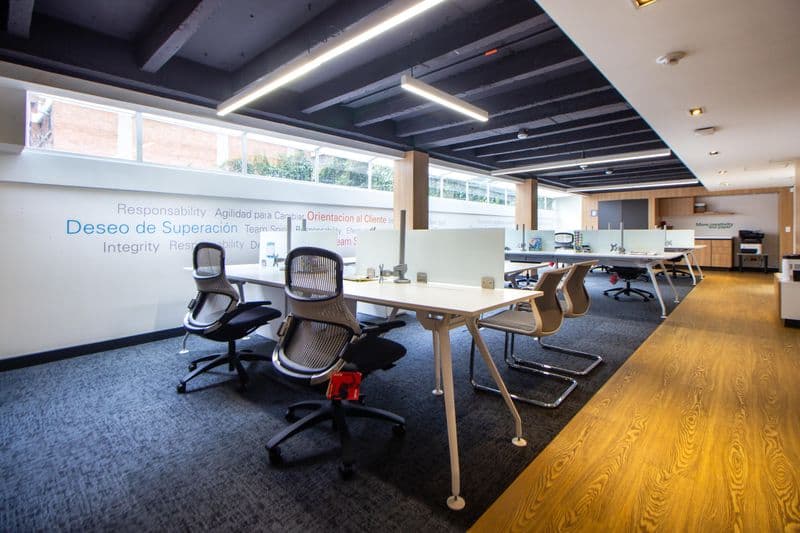 A bright office with clear desks and an open meeting area